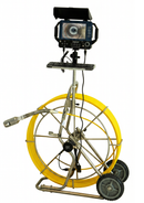 A professional video inspection camera rig with a yellow coiled cable, metal frame, dual wheels, and an attached monitor with a black sunshade on a white background.
